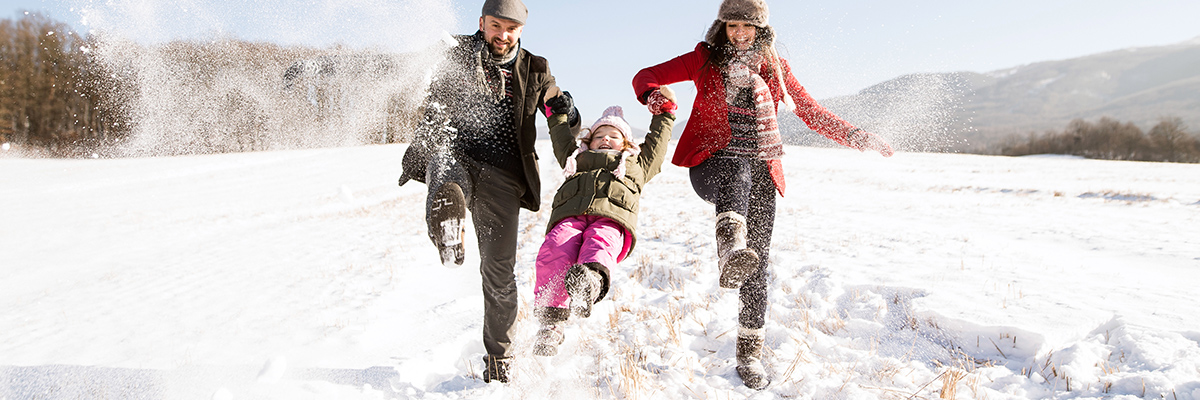 family playing in snow outside park city utah